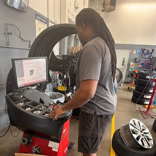 Technician checking inconsistent readings on a wheel balancer in a Southern California tire shop