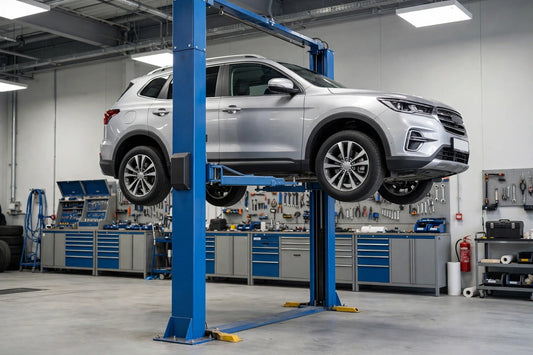 Blue two-post vehicle lift holding an SUV during a vehicle lift safety inspection in a professional auto repair shop